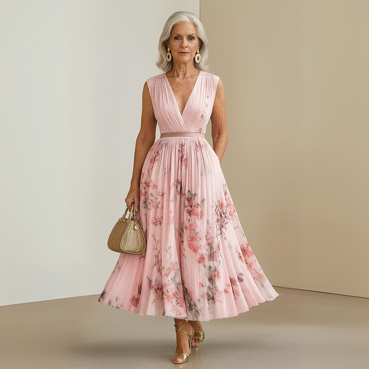 Woman in a printed maxi dress with a sleeveless cut and pleated design.