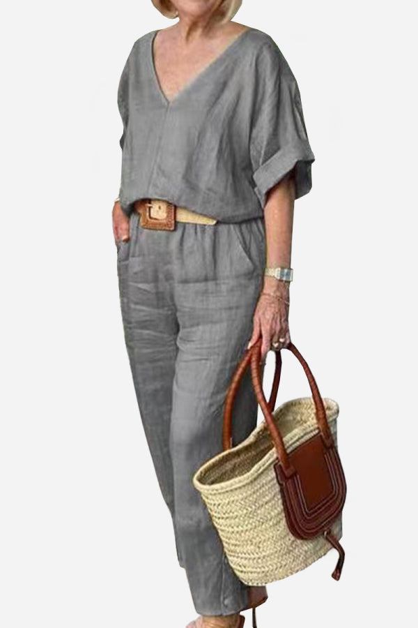  Woman showcasing a coordinated trouser set with a clean silhouette on a plain background.