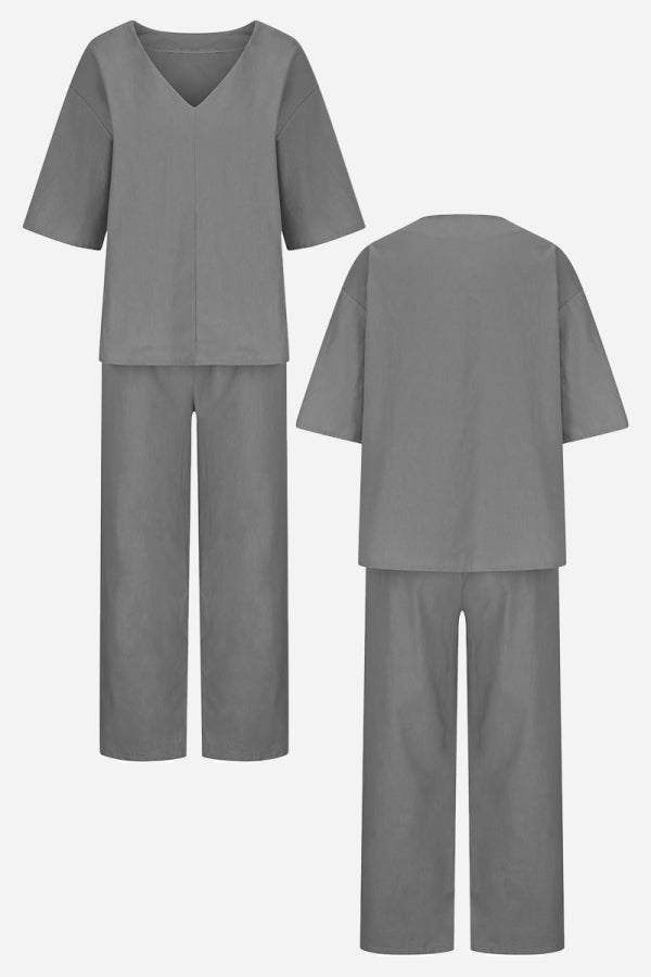  Female model wearing a V-neck top paired with straight-leg trousers in a matching design.