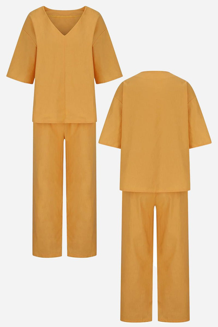  Woman in a matching two-piece set featuring a relaxed top and tailored trousers against a plain background.
