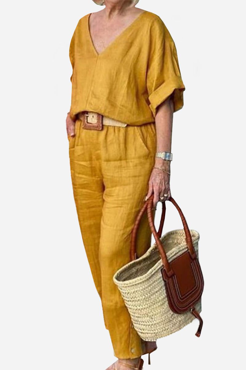  Female model showcasing a coordinated outfit with mid-length sleeves and straight-leg trousers.