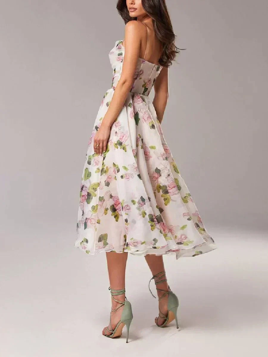  Female wearing a floral occasion dress with a defined waistline on a plain background.