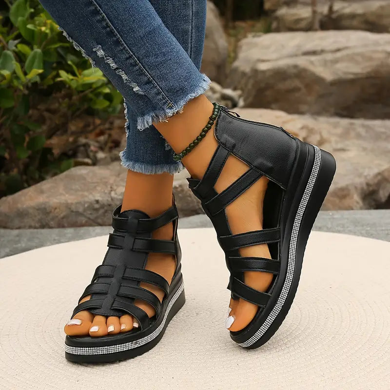 Female modelling open-toe sandals with adjustable straps and cushioned soles.