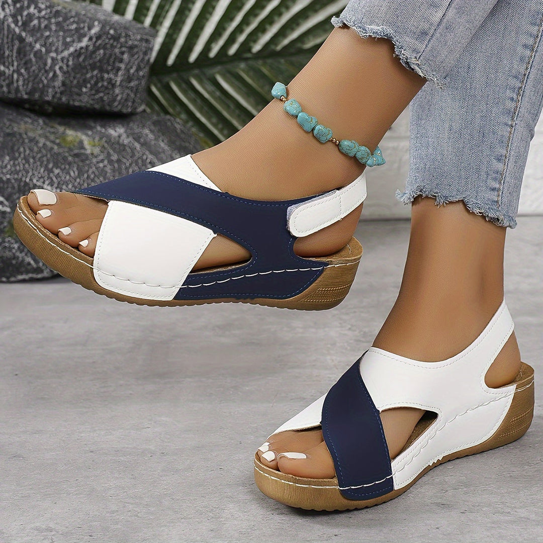 Woman wearing hiking sandals on a plain background.