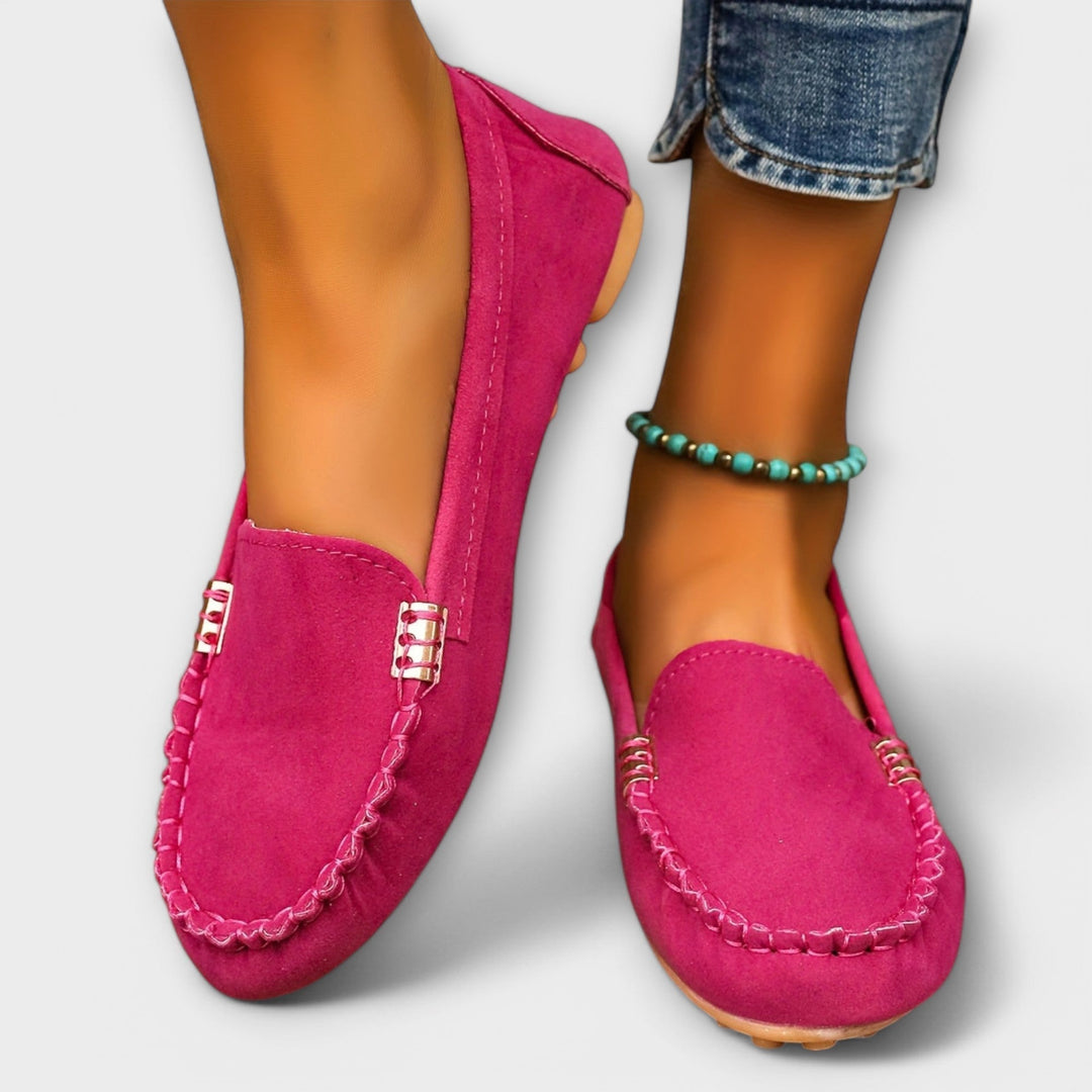 Female model styling casual moccasin slip-on shoes on a plain background.