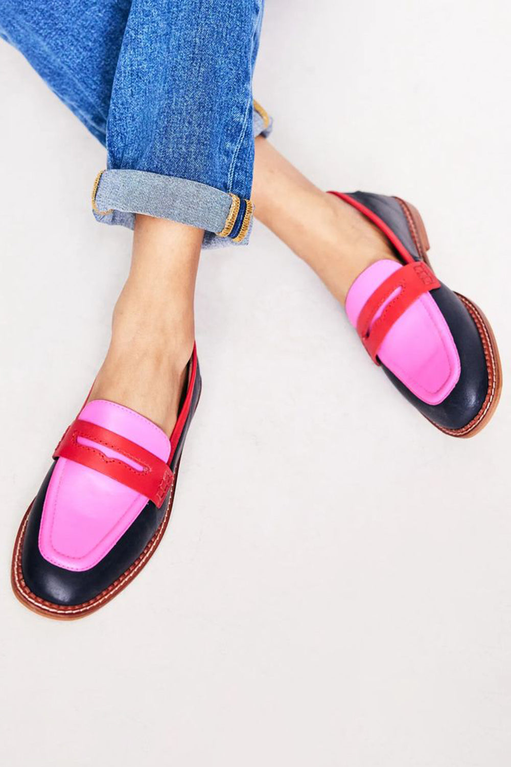 Black women’s loafers with coloured accent on a plain background