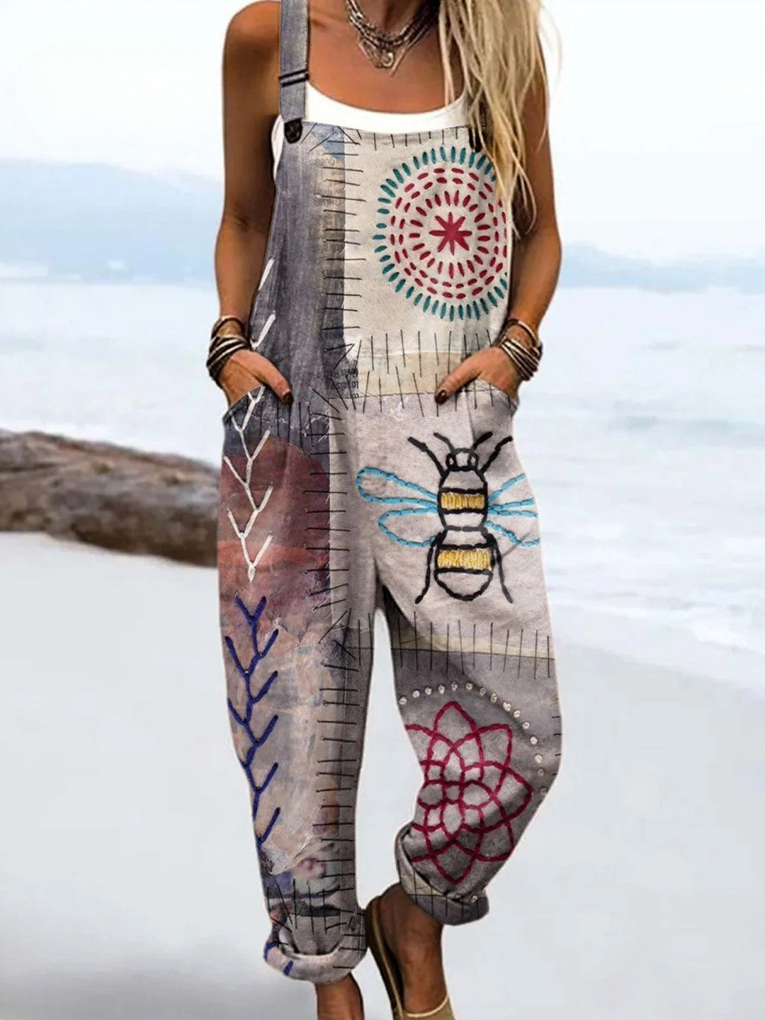 Woman wearing a printed jumpsuit with a flattering one-piece silhouette on a plain background.