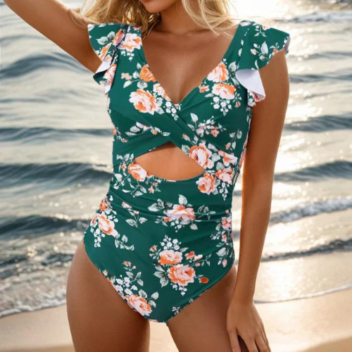 Woman in a ruched one piece swimsuit with side cut out detail on a beach background.