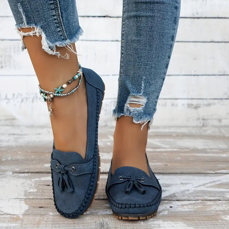 Classic women’s slip-on loafers with a polished finish on a plain background.