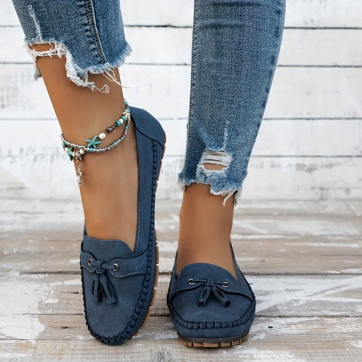 Classic women’s slip-on loafers with a polished finish on a plain background.