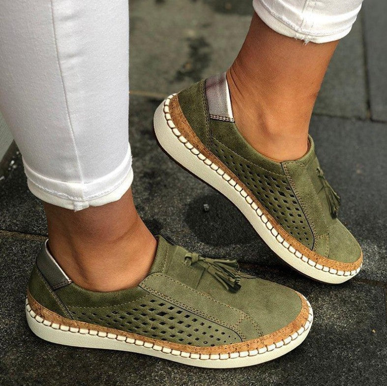 Woman showcasing breathable casual slippers with cushioned sole on a plain background.