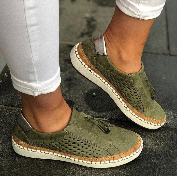 Woman showcasing breathable casual slippers with cushioned sole on a plain background.
