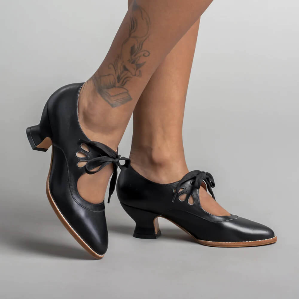 Woman wearing vintage-inspired heels against a plain background.