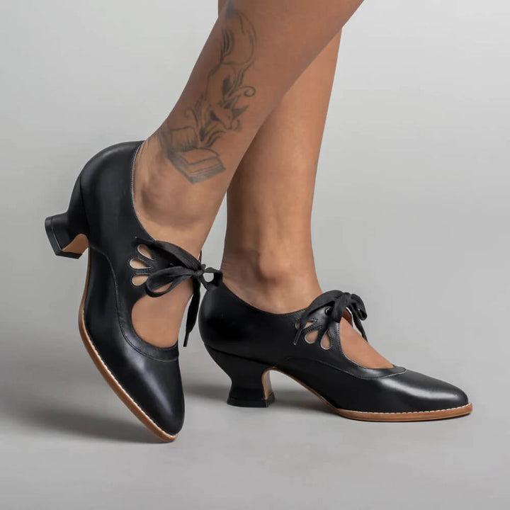 Woman wearing vintage-inspired heels against a plain background.
