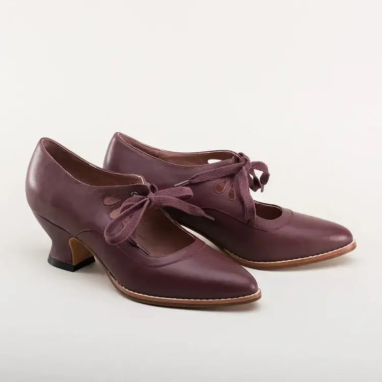 Classic ankle strap shoes on a plain background.