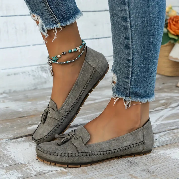 Elegant women’s loafers with decorative bow shown on a plain background.