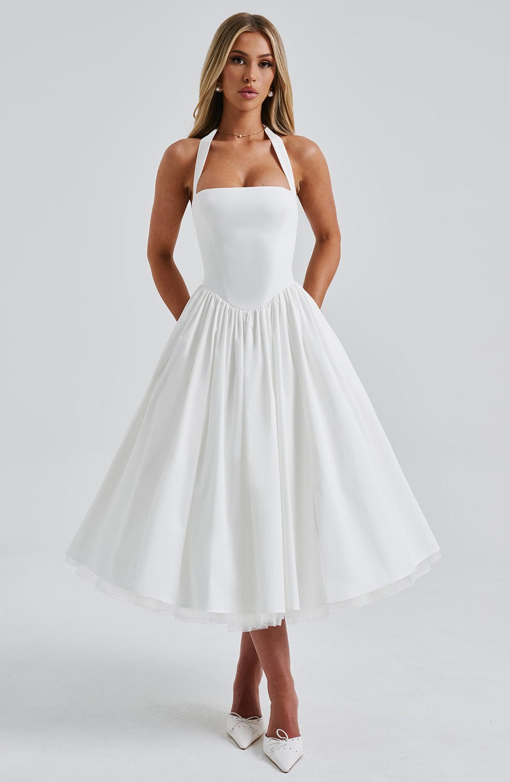 Model wearing a fitted bodice midi dress with a flowing skirt on a plain background.