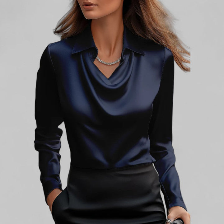  Female model in a relaxed fit blouse with long sleeves and a refined neckline.asion we