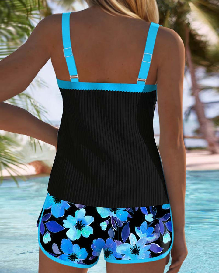 Woman posing in a supportive two-piece swim outfit with sleek shaping detail on a plain background.