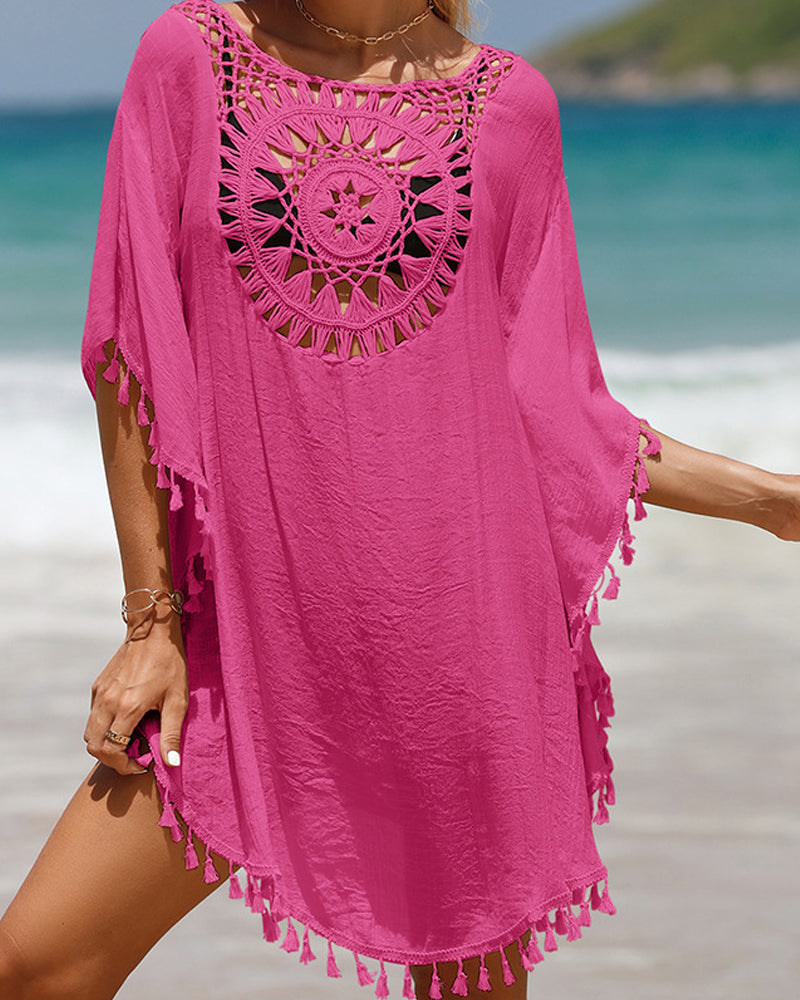 Woman in a relaxed boho beach cover up with open crochet detailing on a plain background.