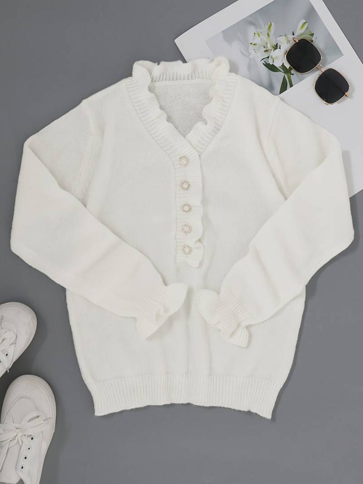 Elegant ruffle neckline blouse on a plain background.