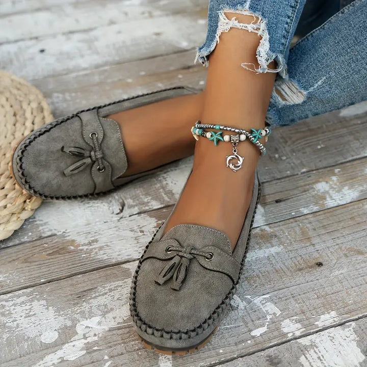 Women’s vintage-inspired flats with rounded toe on a plain background.