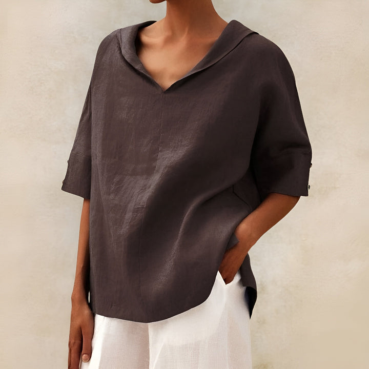  Woman modelling a flowing blouse with a loose silhouette on a plain background.