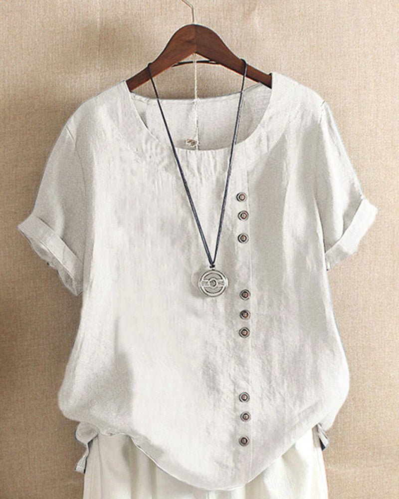  Female modelling a crew neck top with decorative front buttons on a plain background.