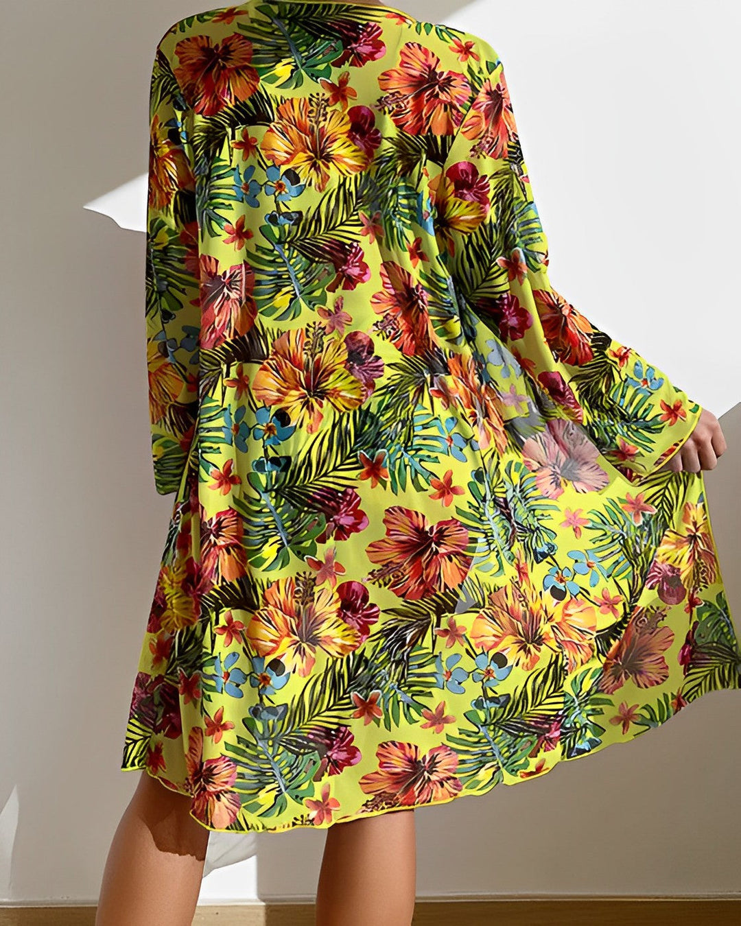 Woman in a floral bikini with coordinated cover-up on a plain background.
