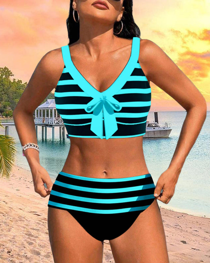 Woman wearing a vibrant tankini swim outfit for beach and pool days on a plain background.