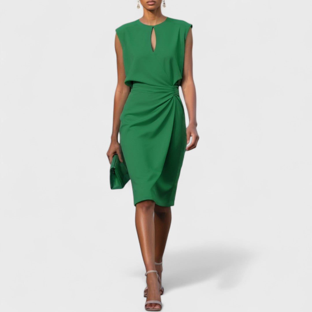  Woman wearing a sophisticated dress with a flowing silhouette on a plain background.