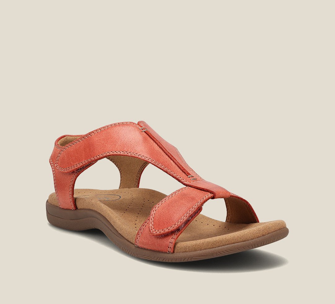 Female wearing stylish T-strap sandals on a plain background.