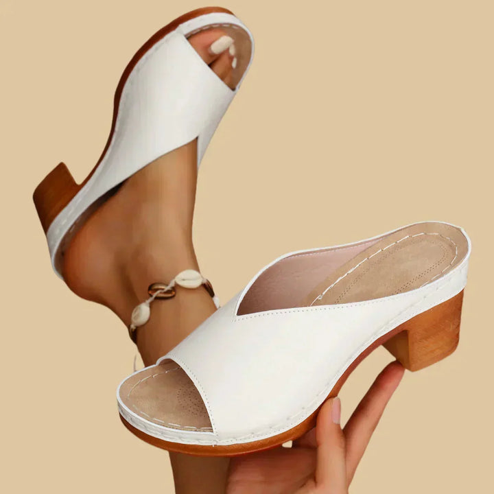 Woman wearing slip-on sandals with an open-toe design.