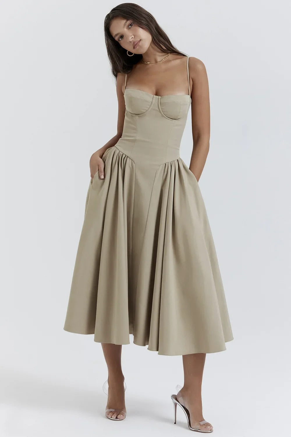 Model wearing a midi dress with delicate straps and a flowing silhouette on a plain background.