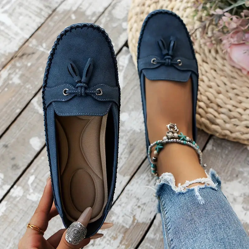 Women’s casual loafers with bow accent displayed on a plain background.