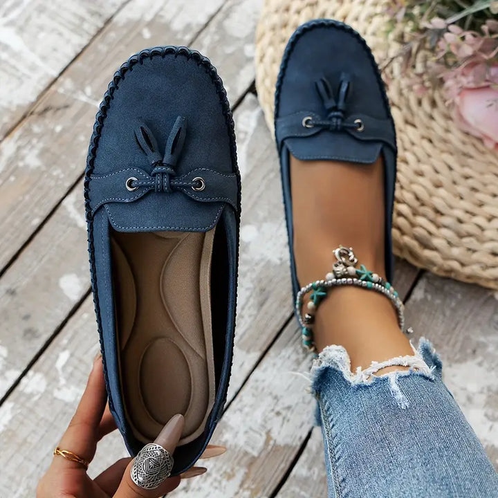 Women’s casual loafers with bow accent displayed on a plain background.