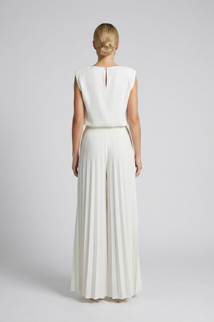 Woman wearing a sleeveless co-ord set with wide-leg trousers on a plain background.