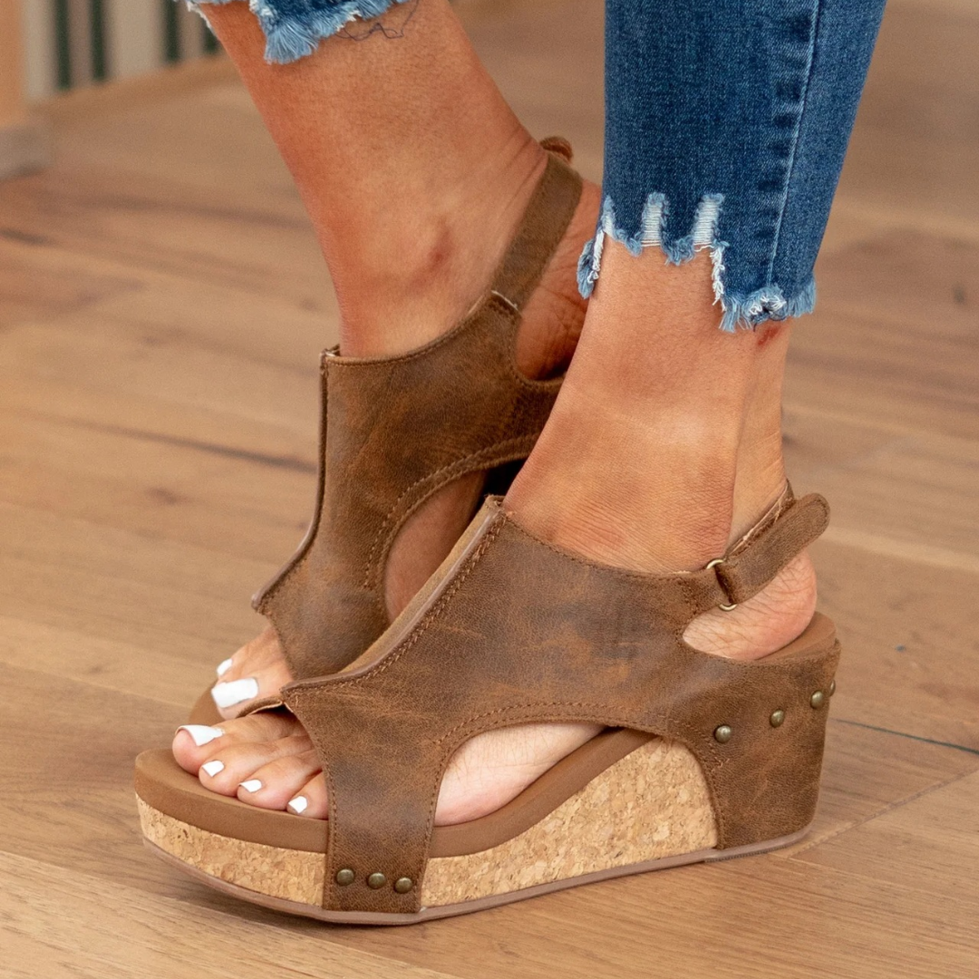 Female model wearing versatile summer sandals on a plain background.