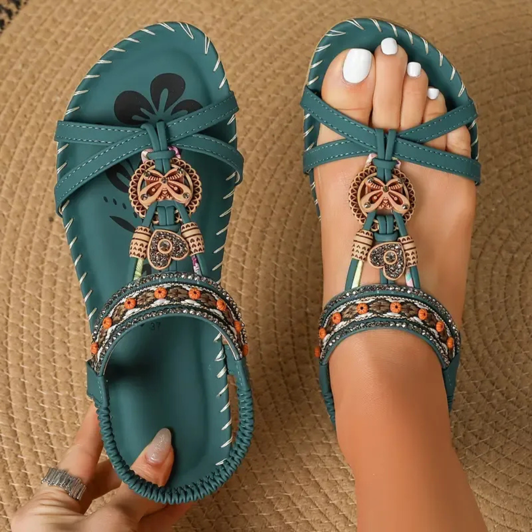 Female model wearing stylish open toe sandals on a plain background.