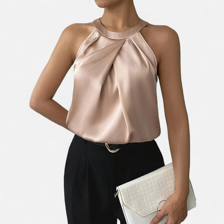 Woman wearing a refined pleated tank for dressy styling on a plain background.