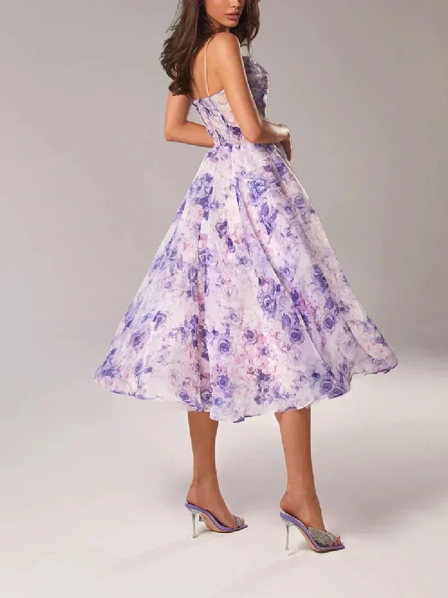  Female model showcasing a floral midi dress with an elegant silhouette on a plain background.