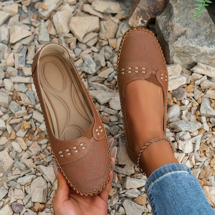 Female model showcasing everyday flats on a nature background.