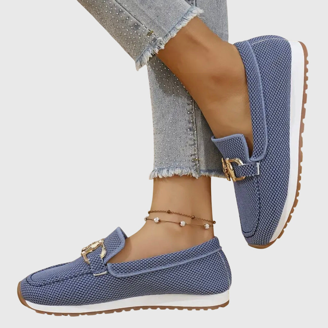 Female wearing cushioned slip-on loafers against a plain background.