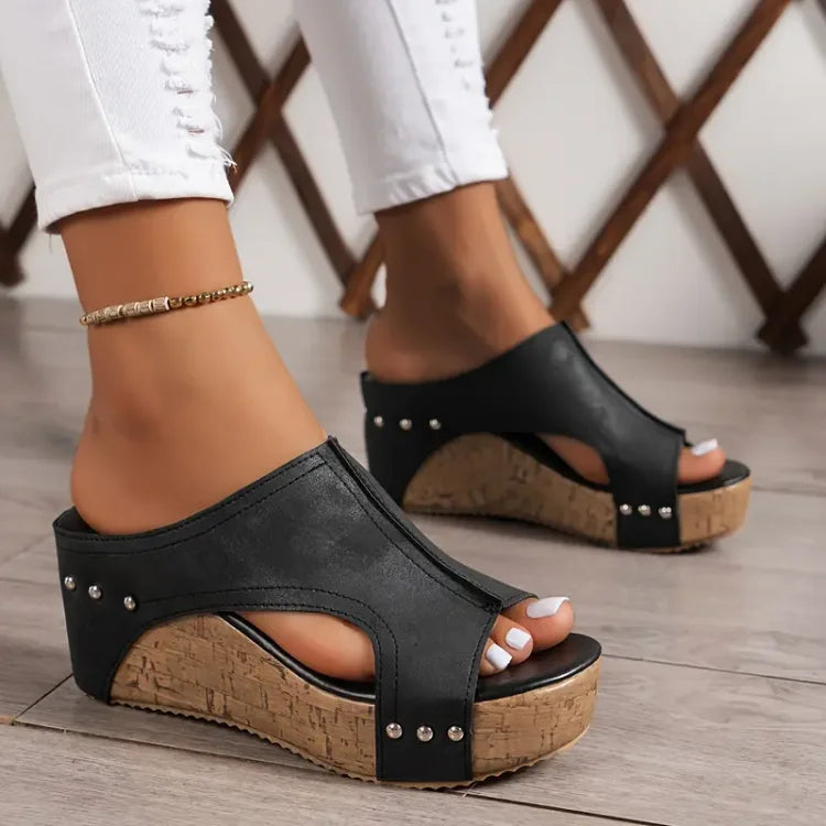 Female wearing cushioned sandals with adjustable straps on a plain background.