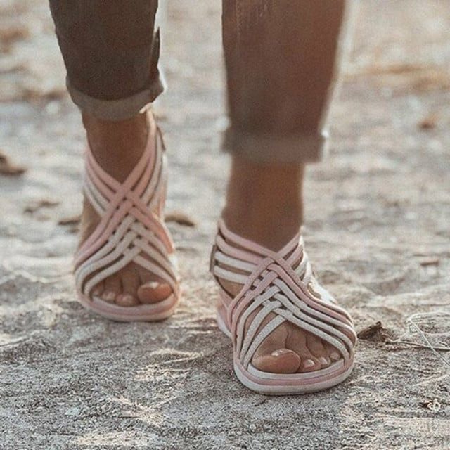 Woman showcasing cushioned sandals against a plain background.