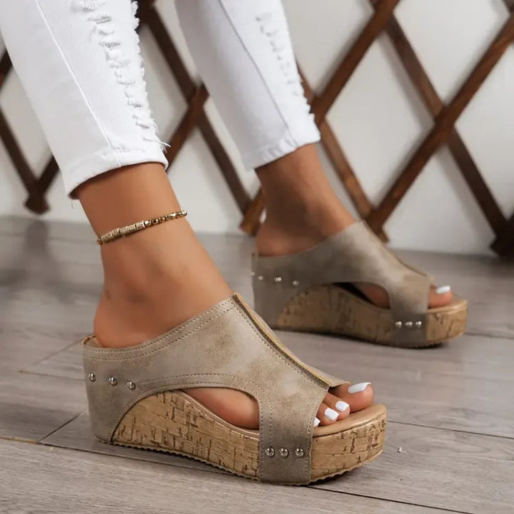Female wearing stylish comfort sandals with secure straps on a plain background.