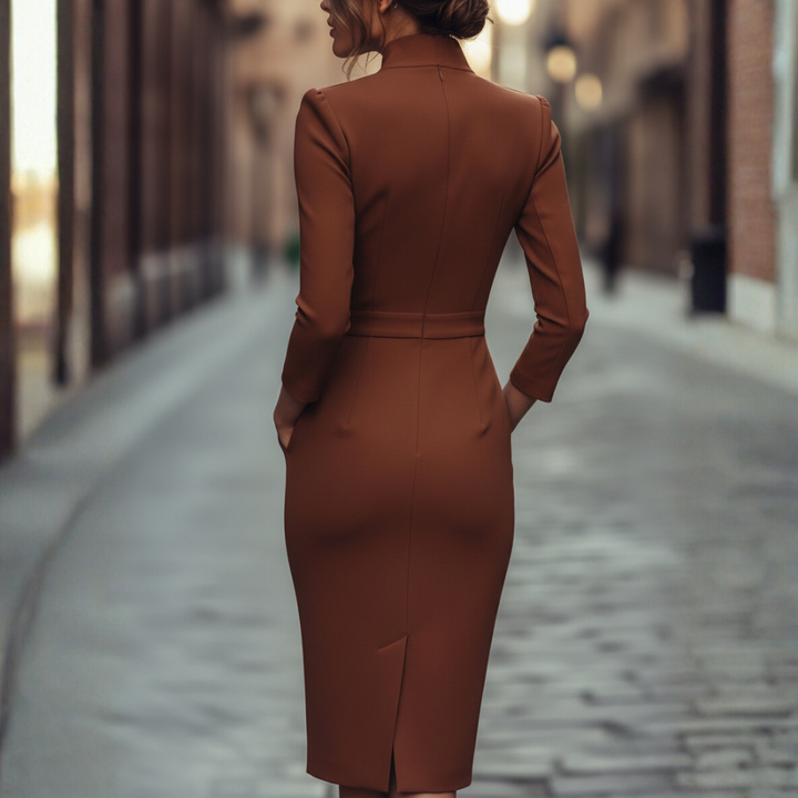 Woman posing in a structured midi dress with a wrap neckline and tailored waist on a plain background.