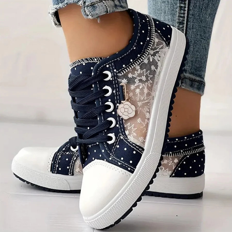  Woman wearing casual lace-up trainers suitable for everyday wear on a plain background.