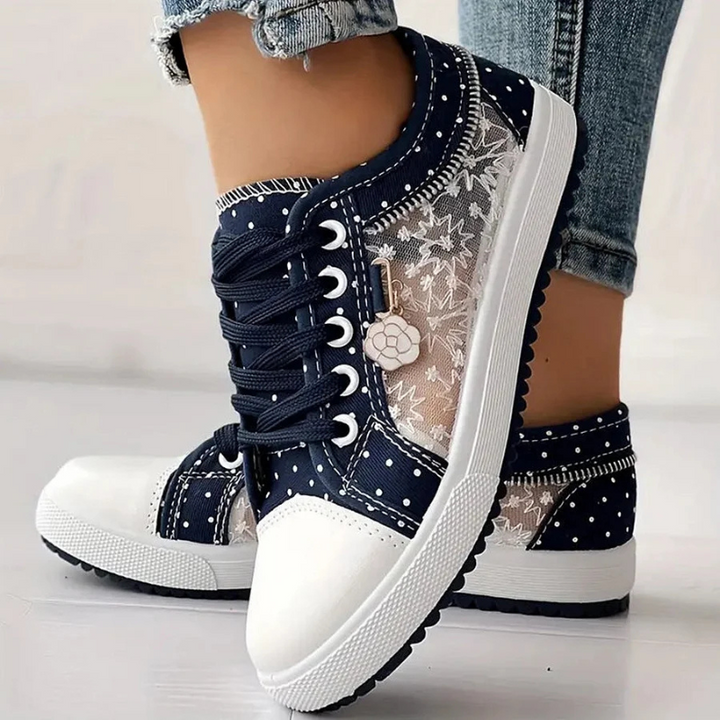  Woman wearing casual lace-up trainers suitable for everyday wear on a plain background.