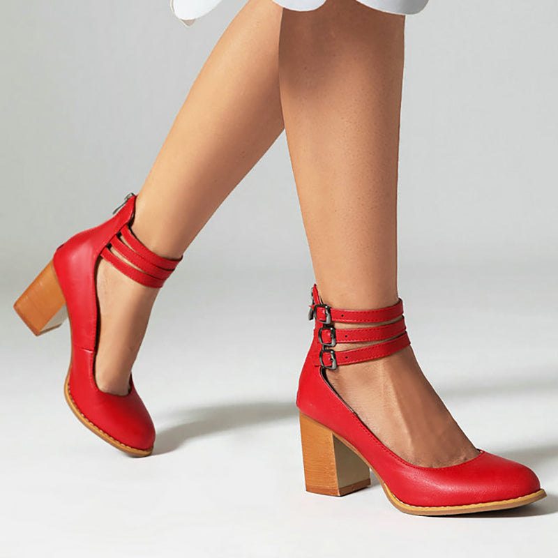 Woman modelling sleek heeled sandals against a plain background.